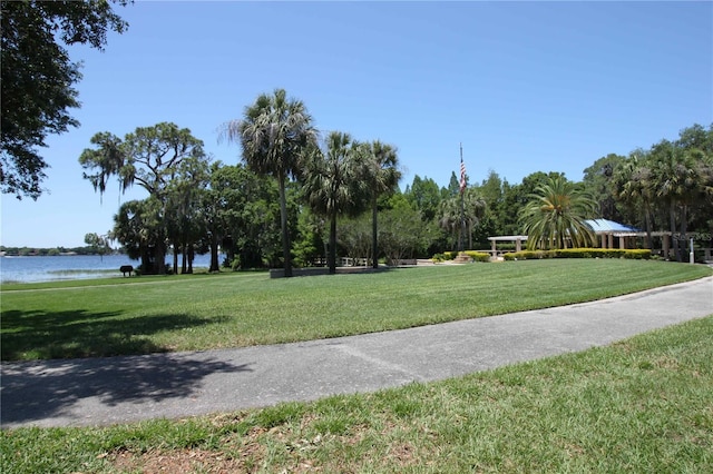 view of property's community with a yard and a water view