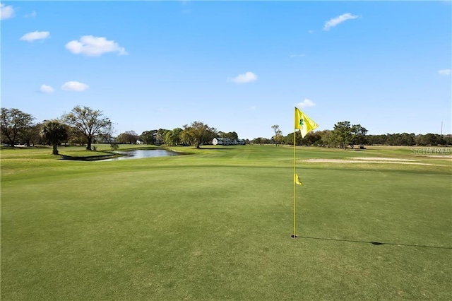 view of property's community featuring a water view, golf course view, and a yard