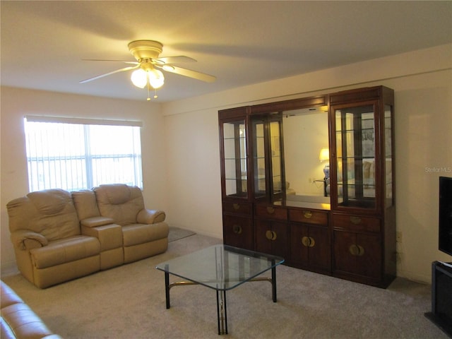 living room featuring a ceiling fan and carpet