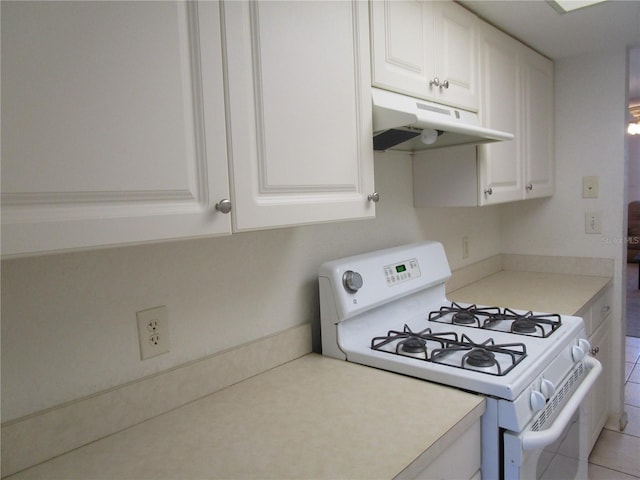 kitchen with under cabinet range hood, white range with gas cooktop, white cabinetry, and light countertops