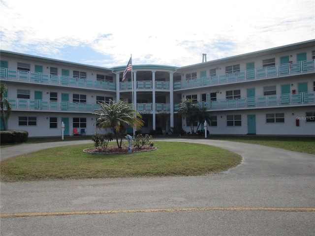 view of building exterior with curved driveway