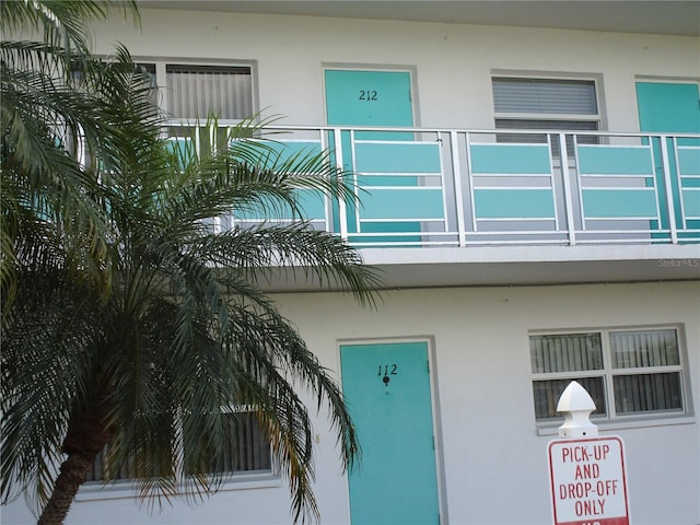 doorway to property featuring a balcony and stucco siding