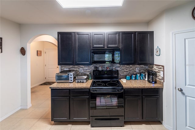 kitchen with a toaster, arched walkways, decorative backsplash, light stone countertops, and black appliances