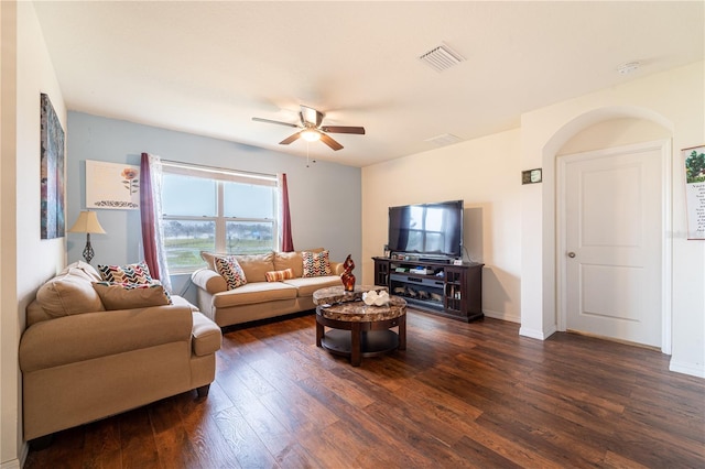 living area featuring a ceiling fan, dark wood-style flooring, visible vents, and baseboards