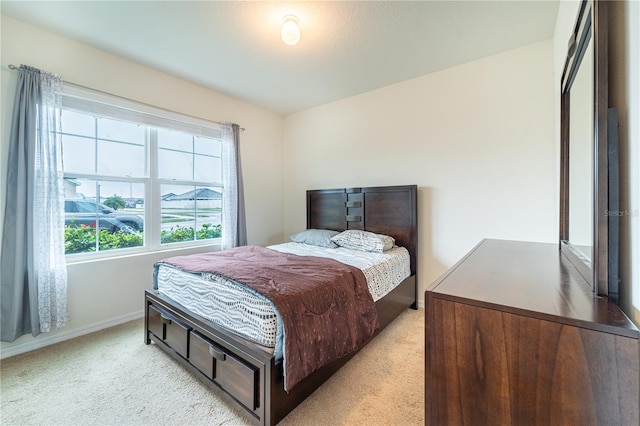 bedroom with light carpet and baseboards