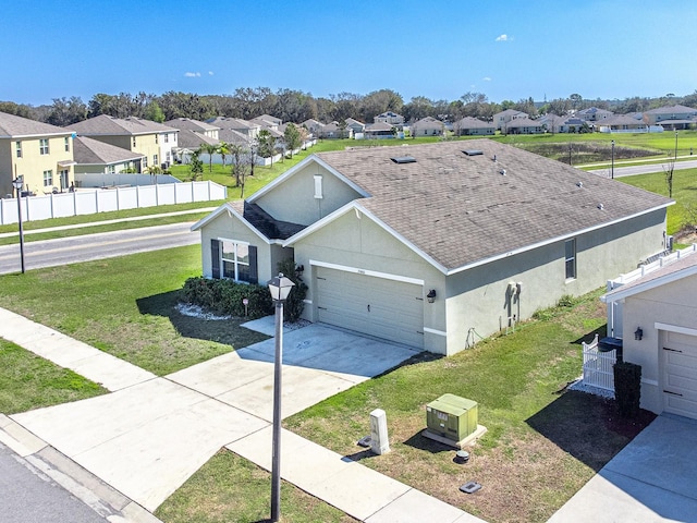 view of front of home featuring stucco siding, a residential view, fence, and a front yard
