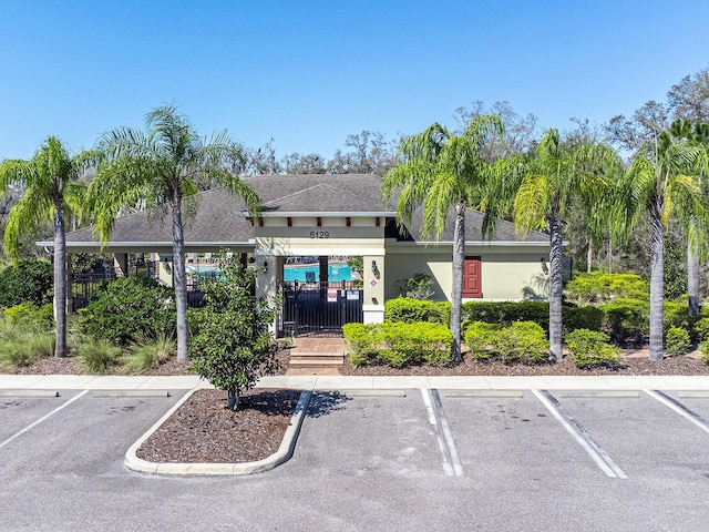 view of building exterior with uncovered parking and fence