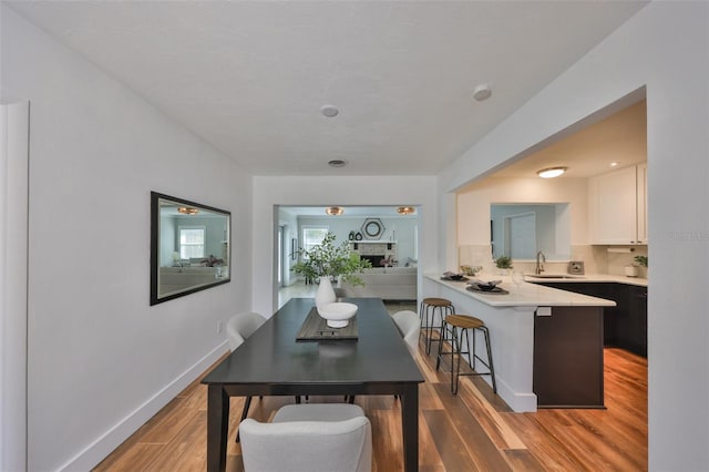 dining area featuring light wood-type flooring and baseboards