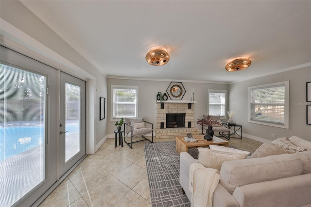 living area with ornamental molding, a wealth of natural light, a fireplace with raised hearth, and light tile patterned floors