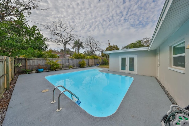 view of swimming pool with a fenced in pool, a patio area, french doors, and a fenced backyard