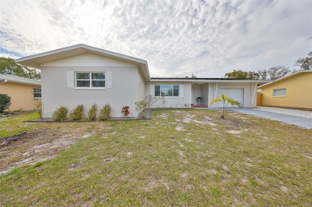 ranch-style house with a garage, concrete driveway, a front lawn, and stucco siding