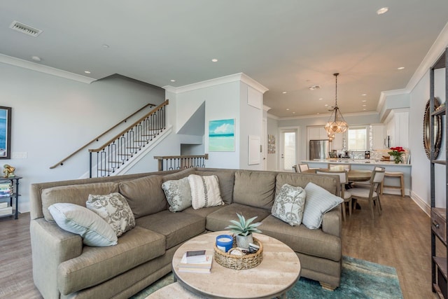 living room featuring visible vents, stairway, ornamental molding, light wood-style floors, and recessed lighting