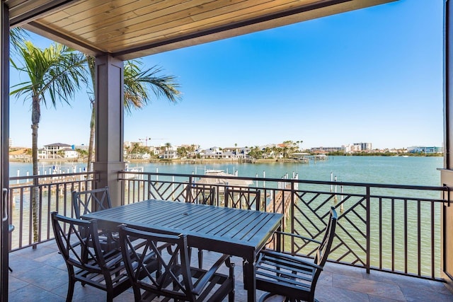 balcony featuring a water view and outdoor dining space