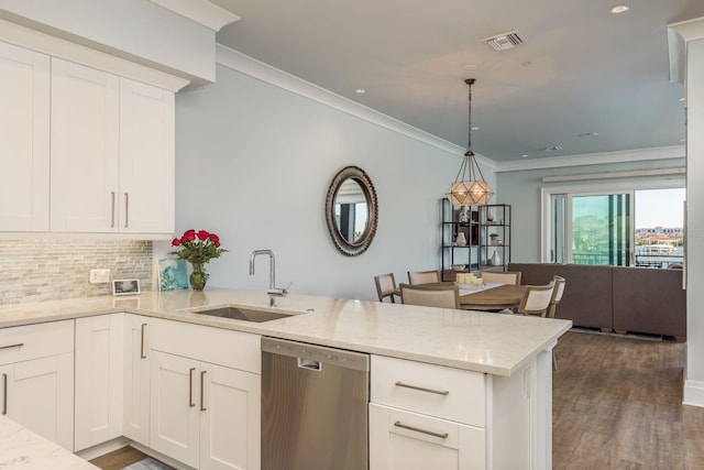 kitchen featuring visible vents, hanging light fixtures, a sink, dishwasher, and a peninsula