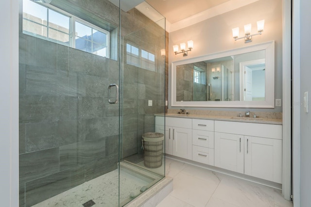 full bathroom with double vanity, marble finish floor, a sink, and a stall shower