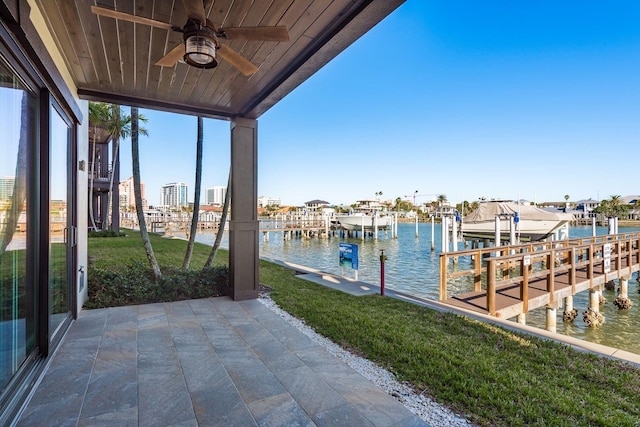 view of dock featuring a lawn, a water view, and boat lift