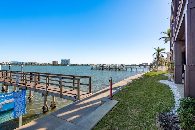 view of dock featuring a water view and a lawn