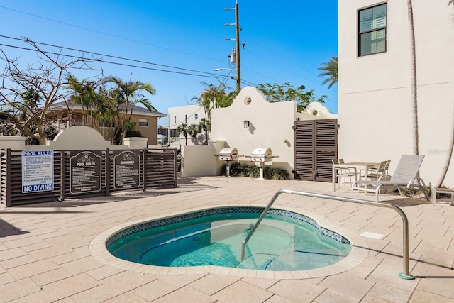 view of pool featuring a hot tub and a patio