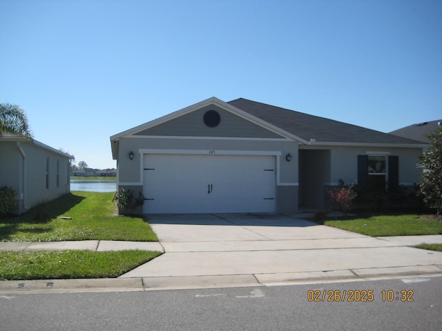 ranch-style house with a water view, driveway, an attached garage, and a front yard