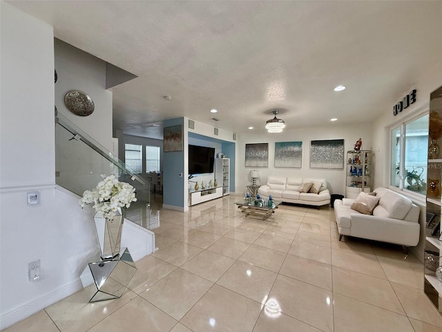 living area featuring light tile patterned floors, baseboards, a textured ceiling, and recessed lighting