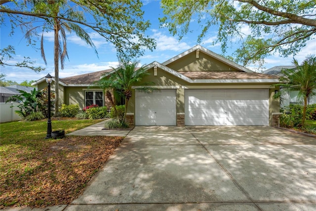 ranch-style house featuring concrete driveway, an attached garage, a front yard, and stucco siding