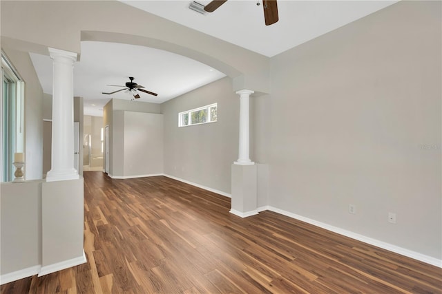 unfurnished living room with ornate columns, baseboards, a ceiling fan, and wood finished floors