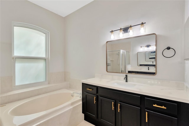 bathroom with a bath, a stall shower, and vanity