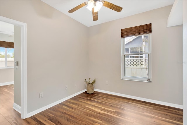 spare room featuring ceiling fan, baseboards, and wood finished floors