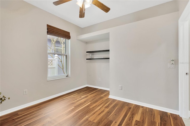 empty room featuring baseboards, ceiling fan, and wood finished floors