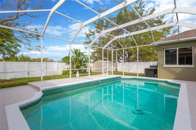 view of pool featuring glass enclosure, a fenced in pool, a fenced backyard, an outdoor structure, and a storage shed