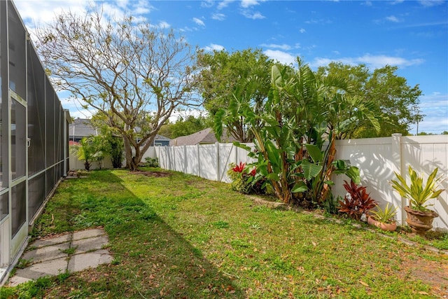 view of yard featuring a lanai and a fenced backyard