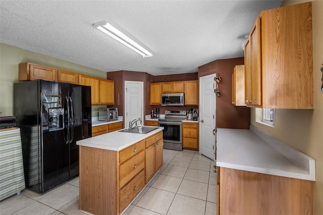 kitchen featuring light tile patterned floors, a center island with sink, appliances with stainless steel finishes, and a sink