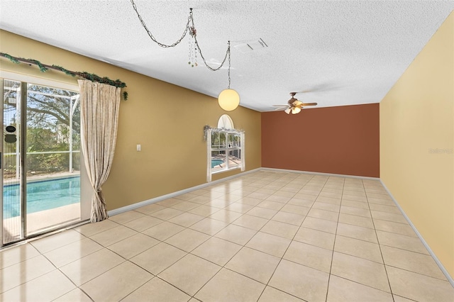 empty room featuring a ceiling fan, visible vents, a textured ceiling, and light tile patterned floors