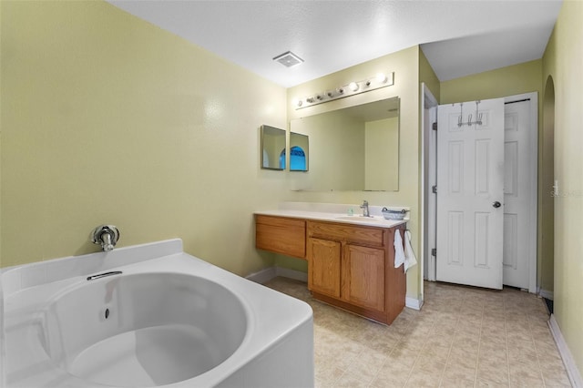 full bathroom with a whirlpool tub, baseboards, visible vents, and vanity