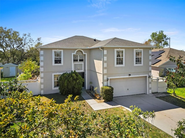 traditional home with a garage, fence, driveway, roof with shingles, and stucco siding