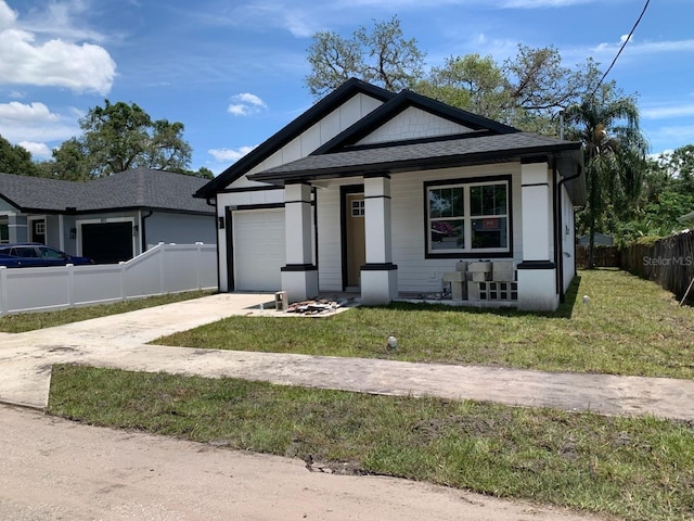 8111 N Edison Ave, Tampa, FL 33610 - view of front of house with driveway, an attached garage, a porch, and roof with shingles