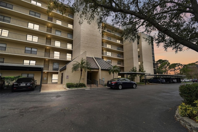 property at dusk featuring covered parking