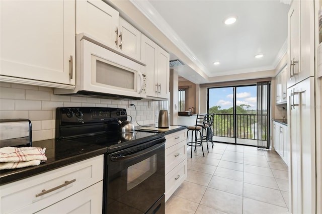 kitchen featuring crown molding, white microwave, white cabinets, and black electric range oven