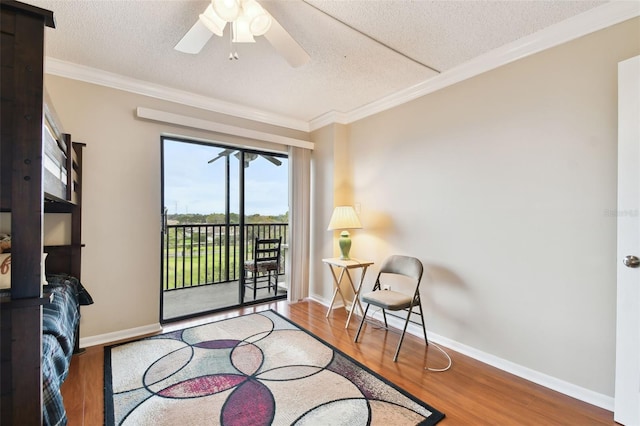 living area featuring crown molding, a textured ceiling, baseboards, and wood finished floors