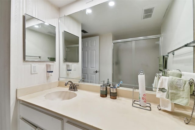 bathroom featuring a shower stall, visible vents, and vanity