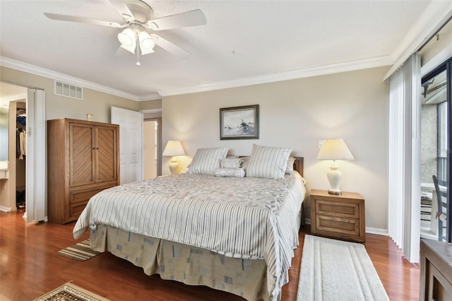 bedroom featuring ceiling fan, wood finished floors, visible vents, baseboards, and crown molding