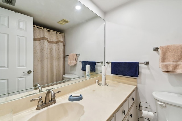 bathroom with visible vents, vanity, and toilet