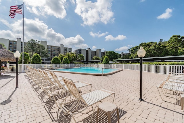 pool with a patio area and fence