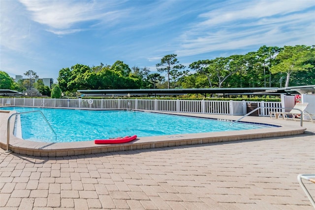 pool with fence and a patio