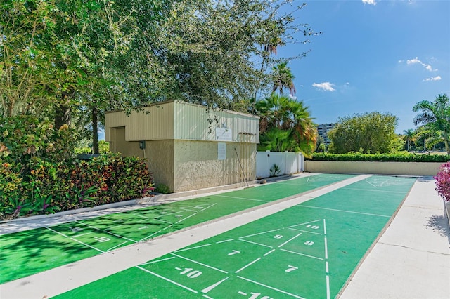 view of home's community with fence and shuffleboard