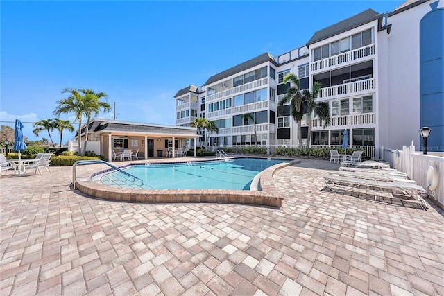 pool with a patio area and fence