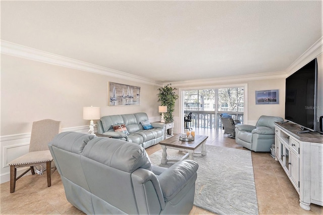 living area featuring crown molding, a decorative wall, light tile patterned floors, and wainscoting