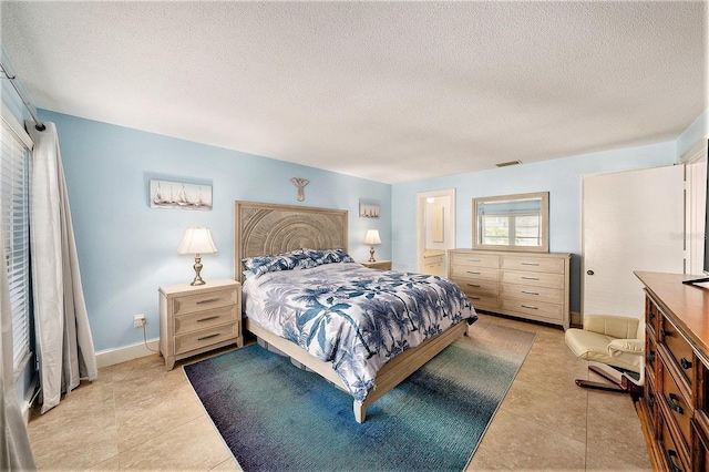 bedroom with light tile patterned flooring, baseboards, visible vents, and a textured ceiling