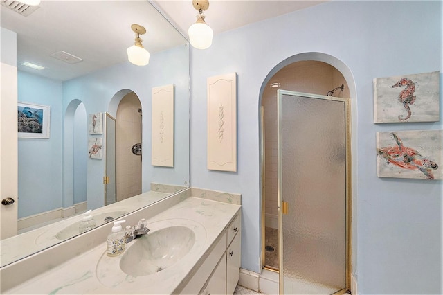 full bathroom with visible vents, vanity, and a shower stall