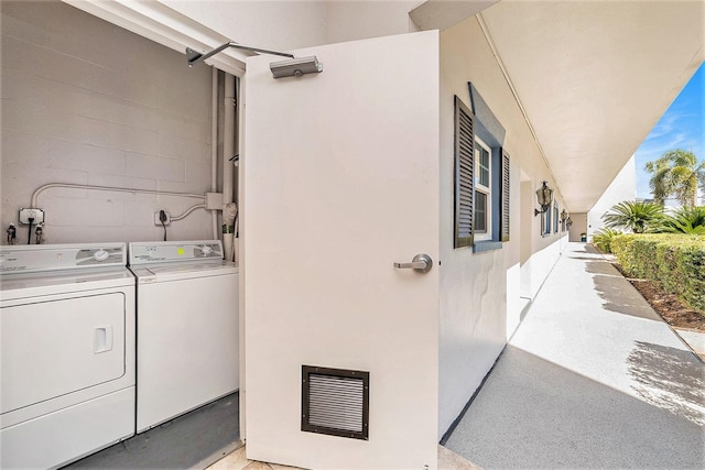 laundry area featuring washer and clothes dryer, visible vents, laundry area, and concrete block wall